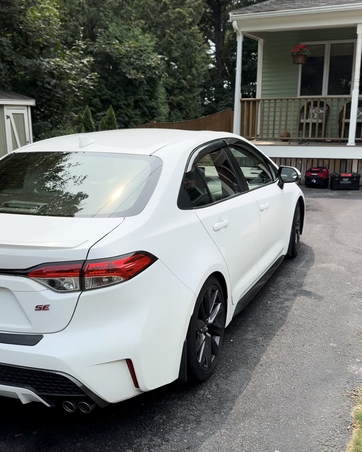 White Toyota Corolla SE rear three-quarter view with gloss black wheels, cleaned and detailed in a residential driveway